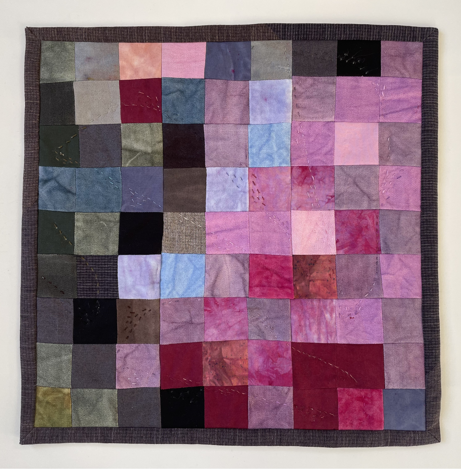 abstract pieced quilt with 9 x 9 squares in magnolia flower colors in the lower right diagonal half