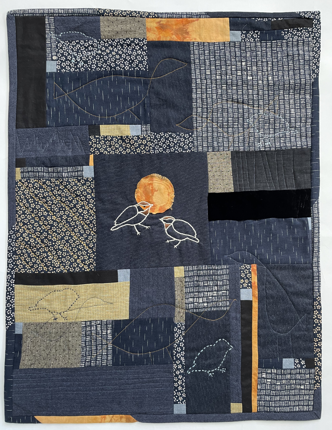collagelike quilt with embroidered chickadees and sun in the center