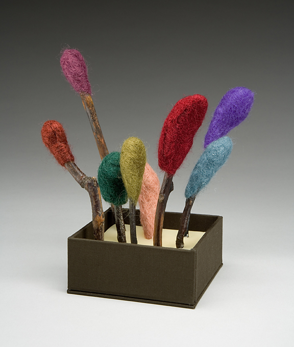 camphor sticks wrapped with different color felt at 
the ends standing in a small box