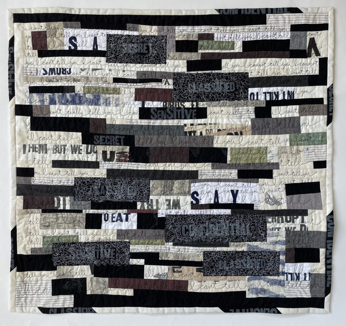 pieced horizontal strip quilt with various textures and printed words crossed out and free motion quilting of the words I can't tell you