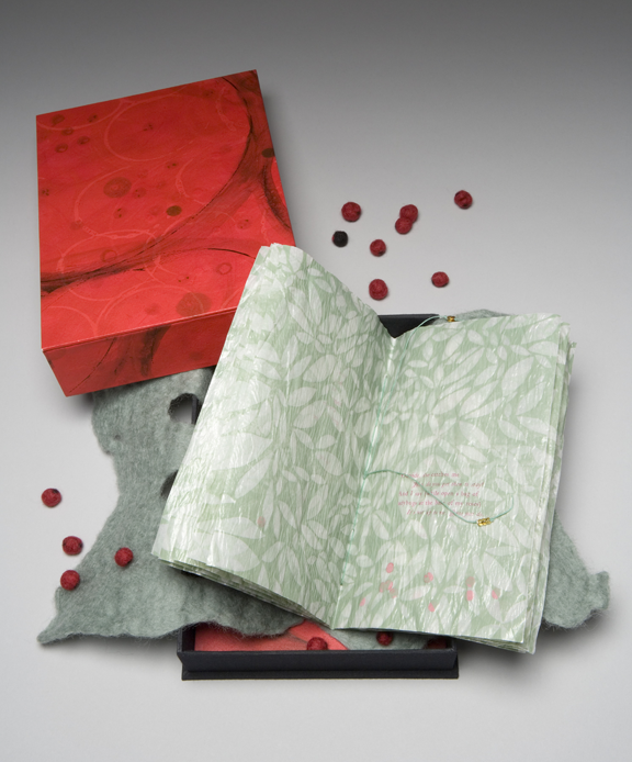 box with book with printed leaves, a felt wrap, and felt balls like ladybugs